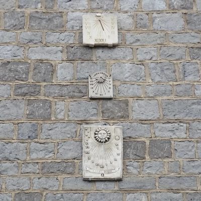 three odd sundials on a wall