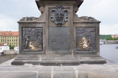 Base of Saint John of Nepomuk statue on Charles Bridge, with two spots rubbed bright
