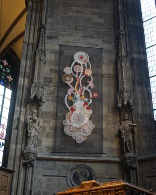An artwork on the wall of the cathedral, consisting of abstract circles of different colours, connected by curved lines