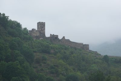 A ruin on a hillside, with a square crenellated tower