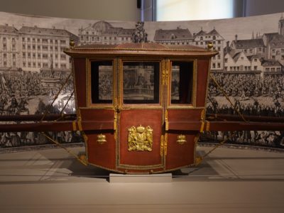 Two-seated dress litter: a small littler in red leather(?) and studded with gold nails