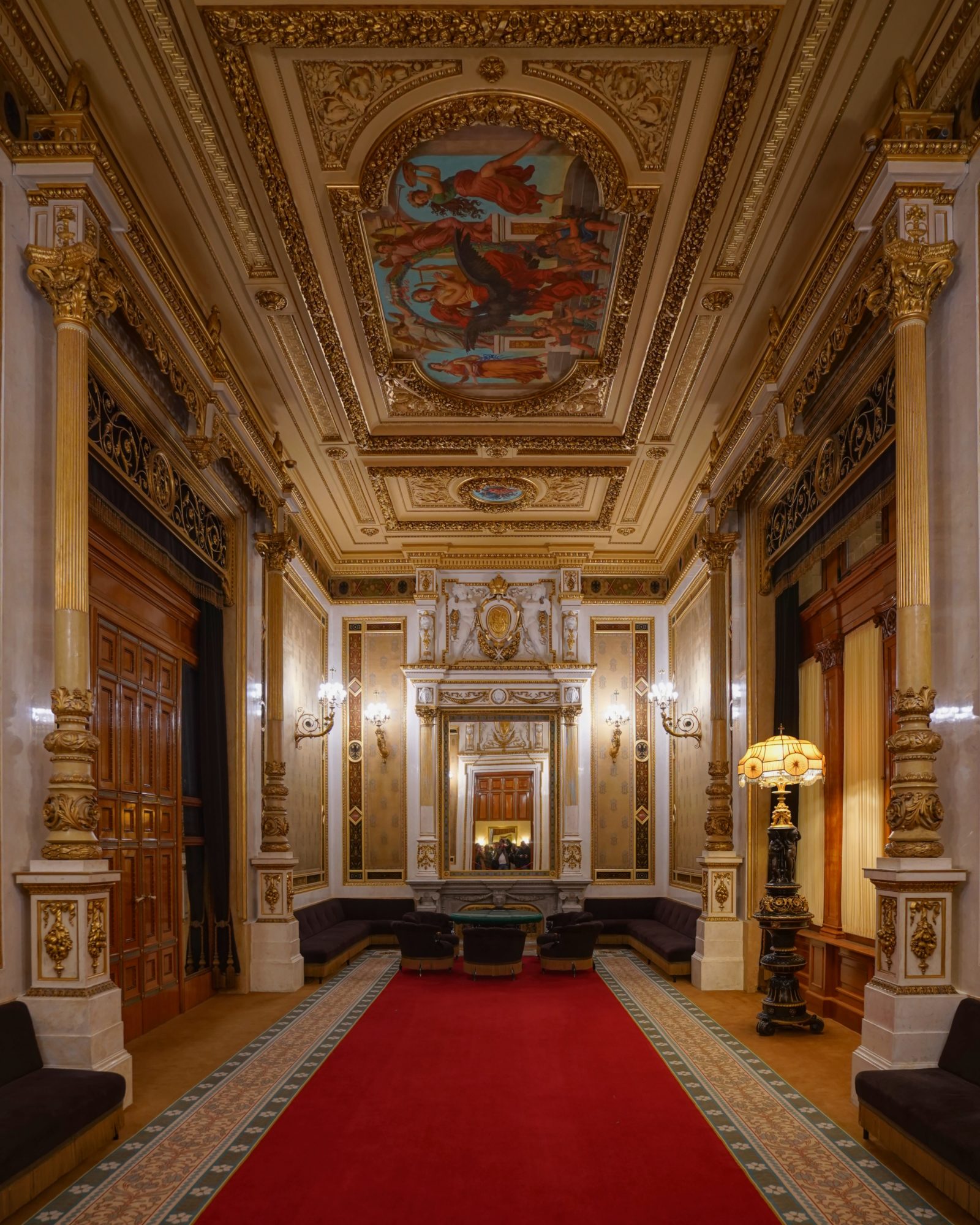 The Tea Room, a gorgeously decorated salon with red carpet, gold decorations, and mirrors