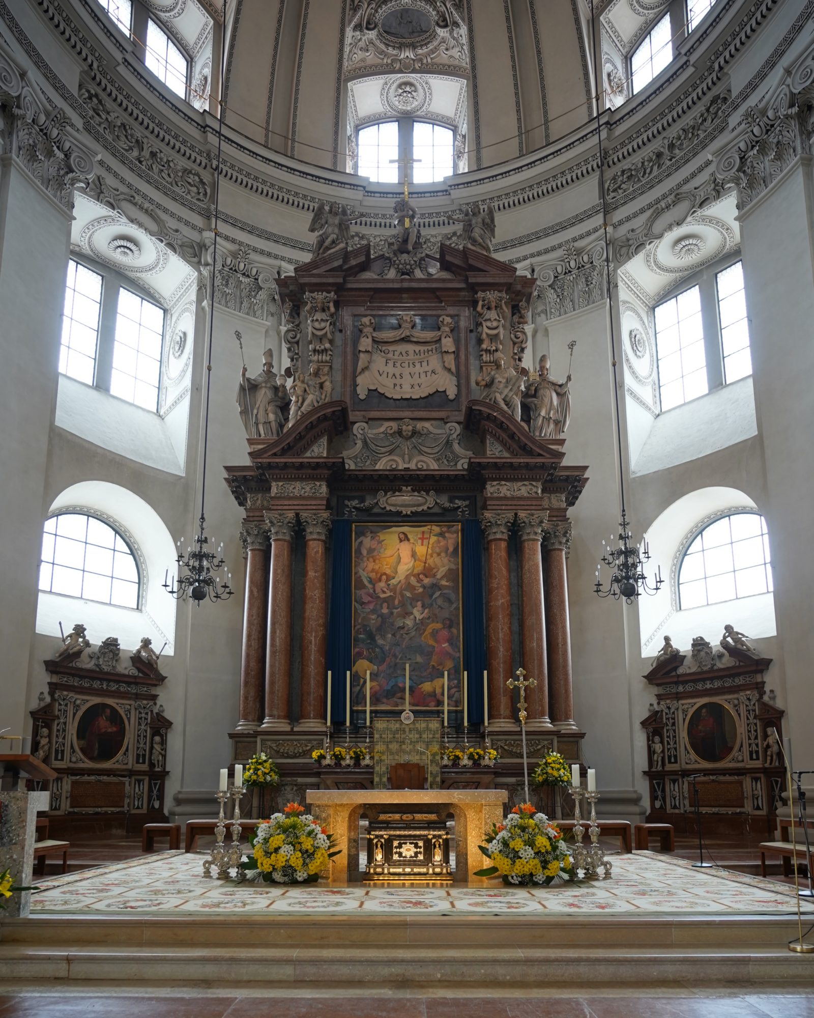 An altar with art and marble columns behind it