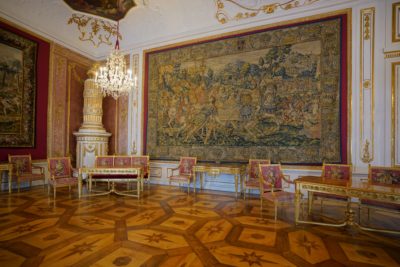 A nicely furnished waiting room with chairs and a couple of tapestries