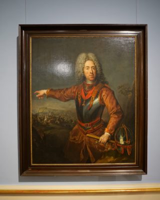 A painting of Prince Eugene of Savoy, with grey wig and red military uniform