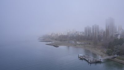 View of Sunset Beach and the West End from Burrard Bridge, in heavy fog. We can't see much further than the Inukshuk, and the tops of the towers are barely visible