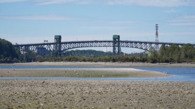 A view of Second Narrows Bridge. The ground is partly dry and partly submerged