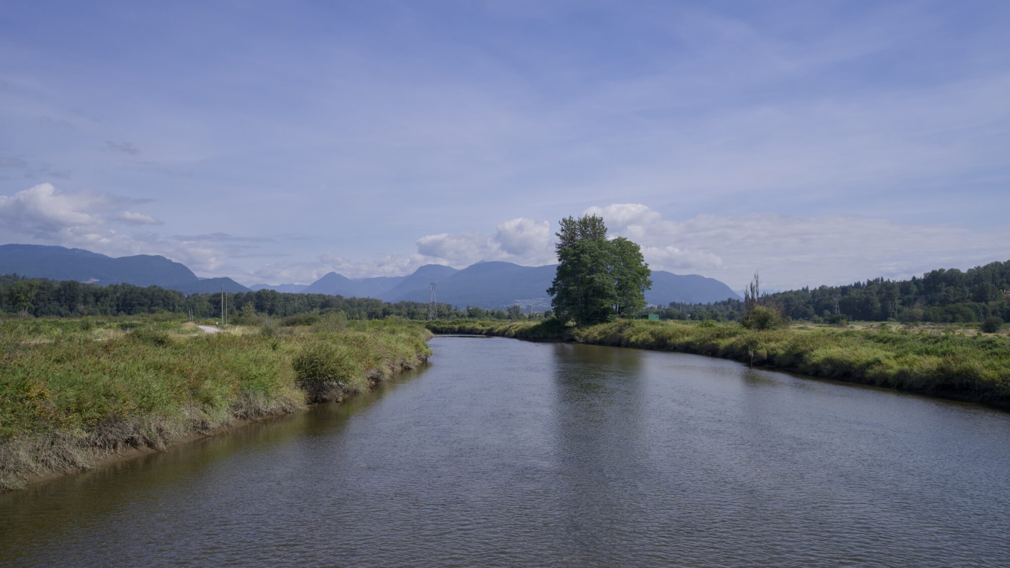 Coquitlam River from the bridge, under a mostly blue sky