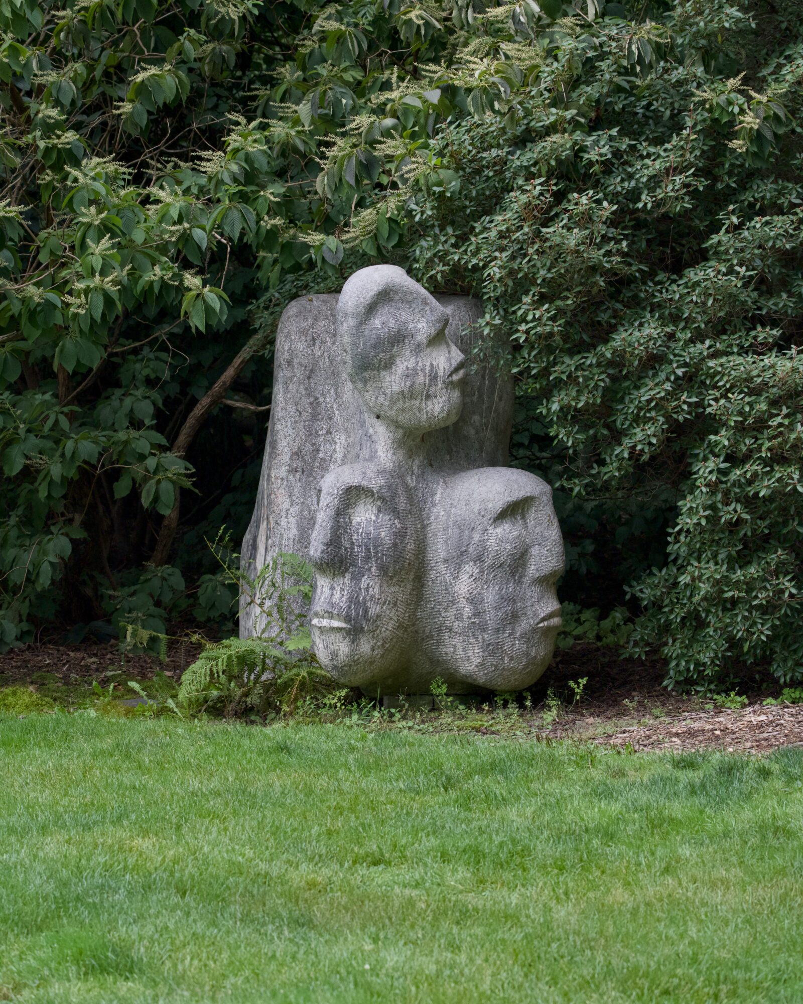 Some abstract stone art piece that kind of looks like 3 faces